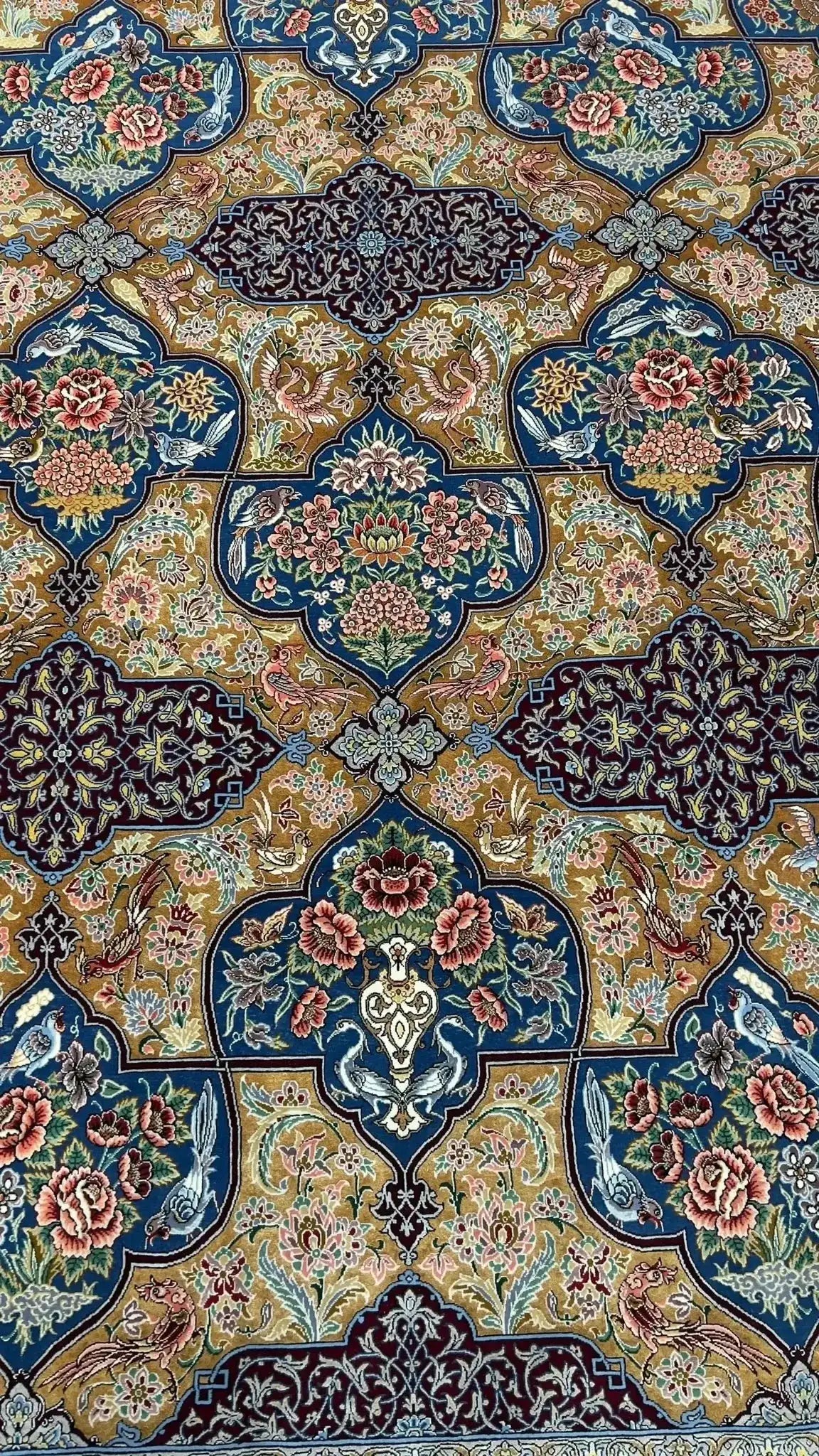 Luxurious Persian rug with detailed floral design and birds, made from 75% silk and wool, handwoven in Isfahan.